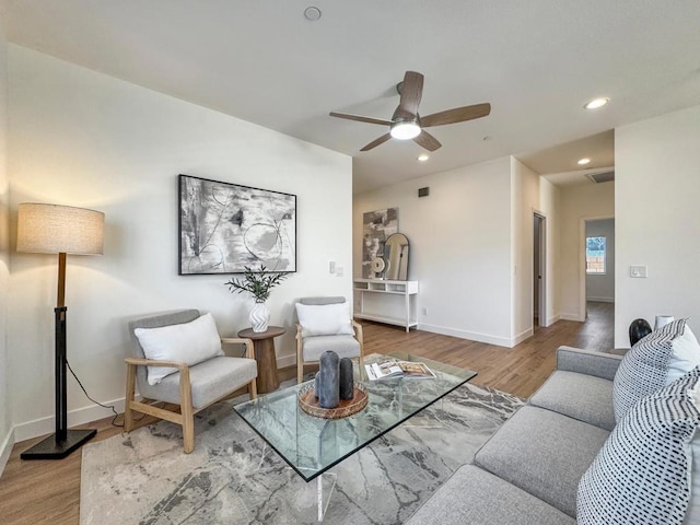 living room featuring hardwood / wood-style floors and ceiling fan