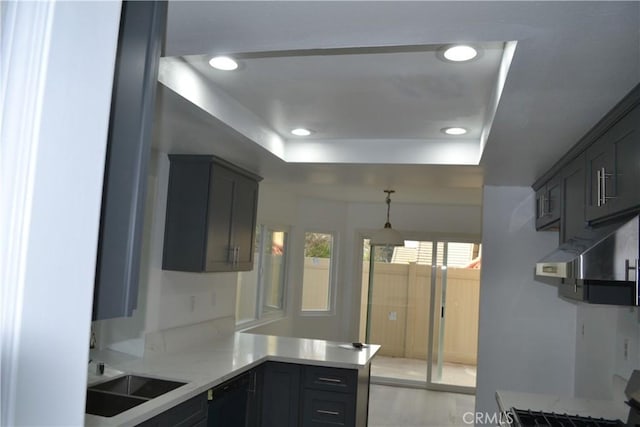 kitchen featuring recessed lighting, light countertops, dishwasher, and a raised ceiling