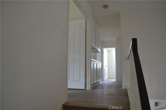 hall with visible vents and dark wood finished floors