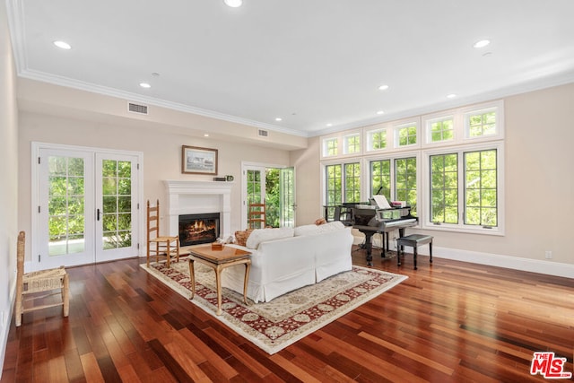 living room with a wealth of natural light, dark hardwood / wood-style flooring, and ornamental molding