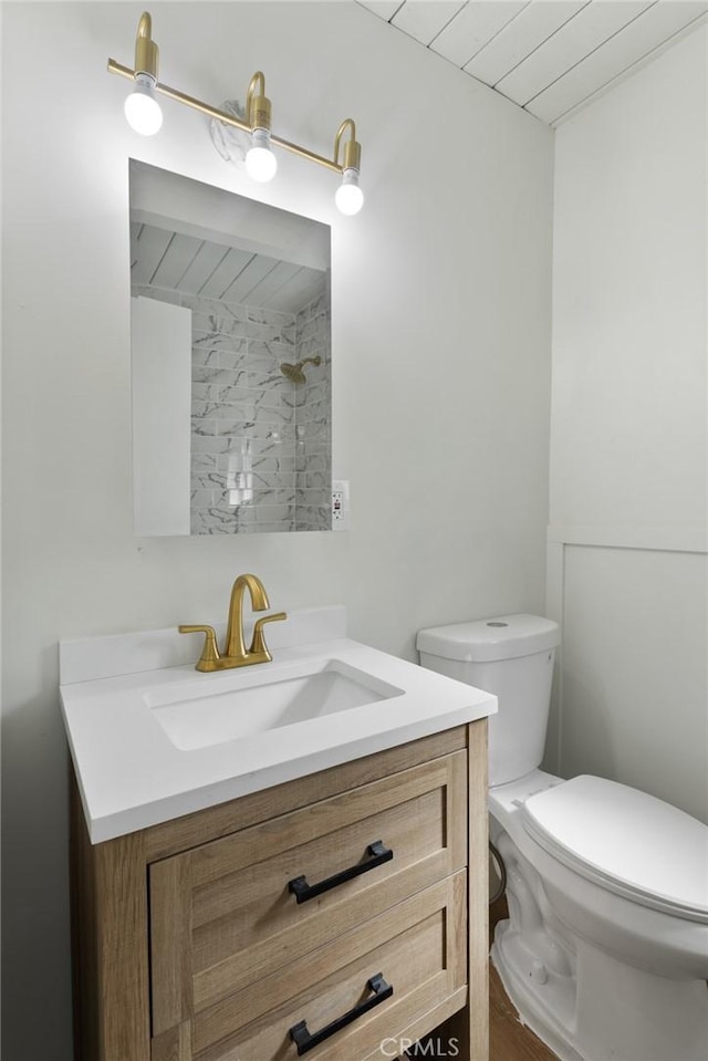 bathroom with toilet, vanity, and hardwood / wood-style flooring