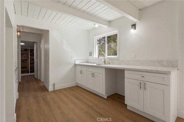 kitchen featuring sink, wooden ceiling, beamed ceiling, light hardwood / wood-style floors, and white cabinetry