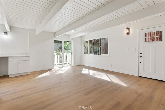 unfurnished living room featuring beamed ceiling, wooden ceiling, and light hardwood / wood-style flooring