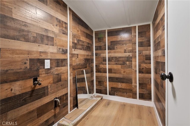 bathroom with hardwood / wood-style floors and wooden walls