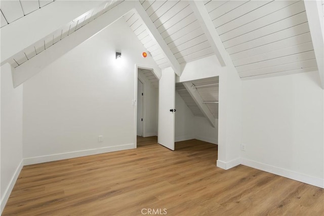 additional living space featuring hardwood / wood-style floors, vaulted ceiling with beams, and wood ceiling