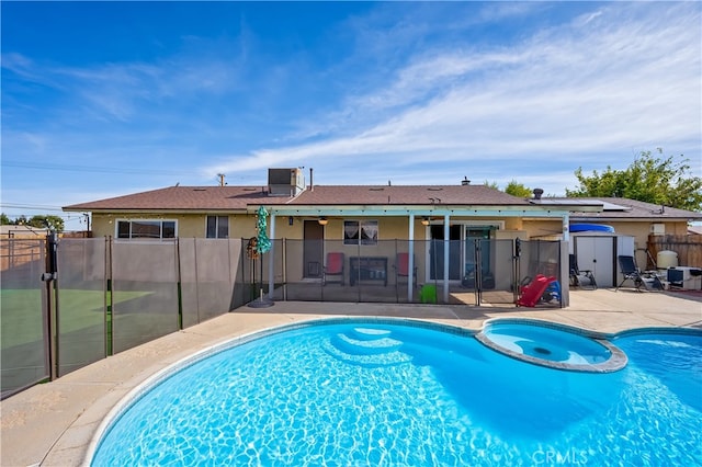 view of swimming pool featuring central air condition unit, a patio area, an in ground hot tub, and a storage unit