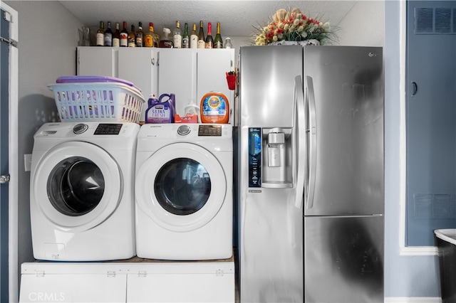 clothes washing area with washer and dryer and a textured ceiling