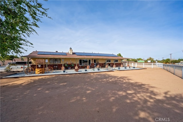 view of front of home featuring solar panels and a patio area