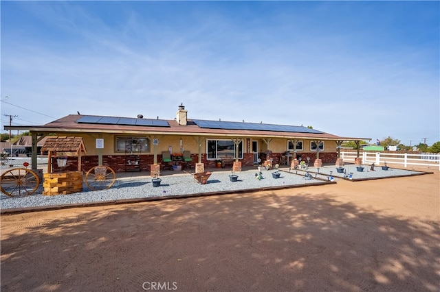 rear view of house featuring a patio and solar panels