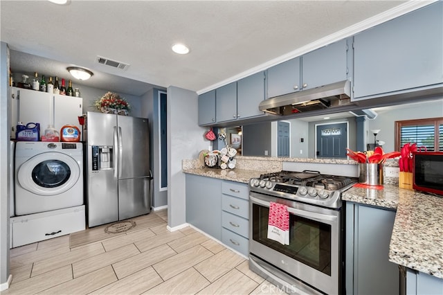 kitchen featuring light stone counters, blue cabinets, washer / clothes dryer, kitchen peninsula, and appliances with stainless steel finishes