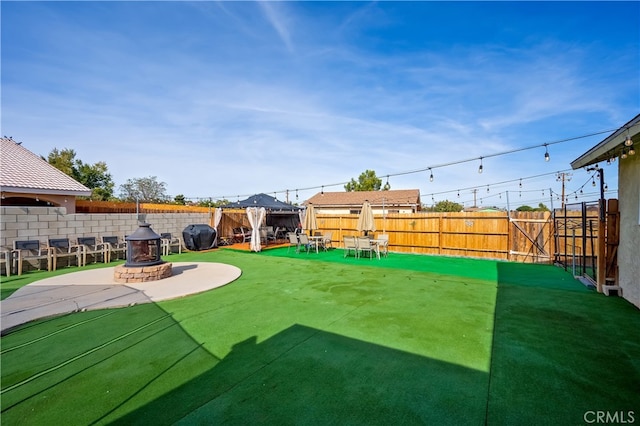 view of yard featuring an outdoor fire pit and a patio area