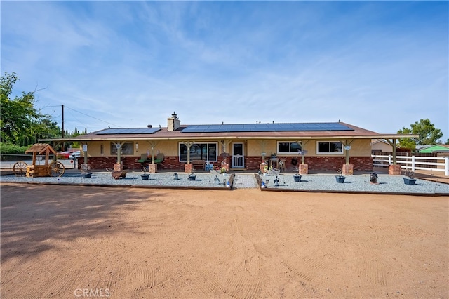 view of front of property featuring solar panels and a porch