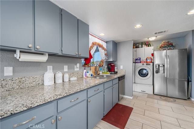 kitchen with sink, stainless steel appliances, and washer / clothes dryer