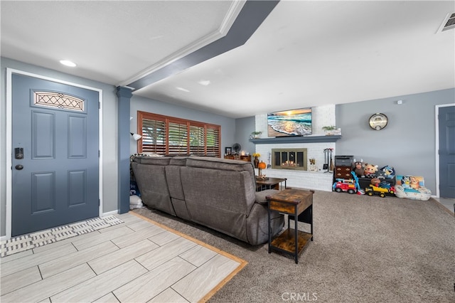 living room featuring light colored carpet, a brick fireplace, and ornamental molding