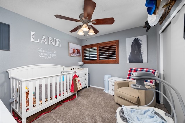 carpeted bedroom with ceiling fan, a closet, and a nursery area