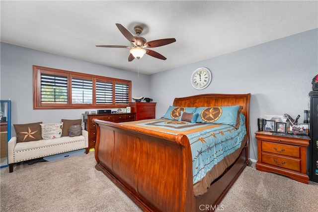 carpeted bedroom featuring ceiling fan and a textured ceiling