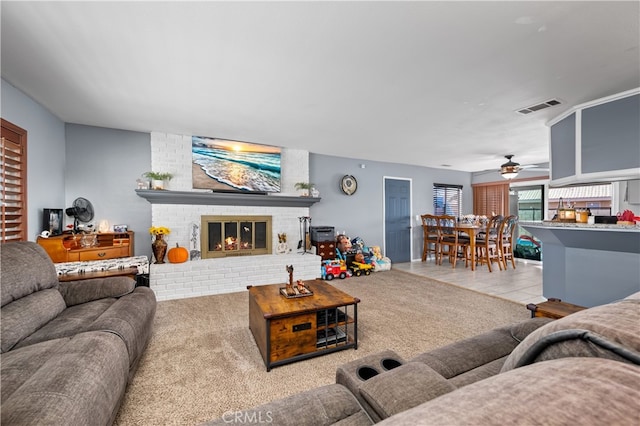 carpeted living room featuring ceiling fan and a brick fireplace