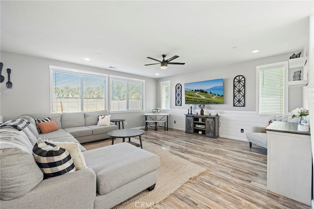 living room featuring ceiling fan and light hardwood / wood-style floors