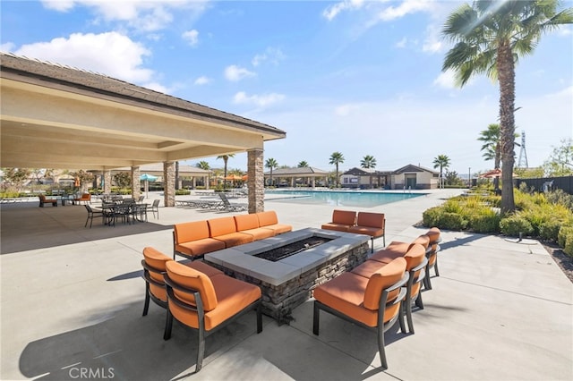 view of patio with a community pool and a fire pit