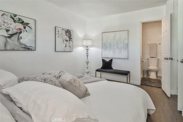 bedroom with dark hardwood / wood-style flooring and connected bathroom