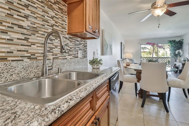 kitchen featuring tasteful backsplash, stainless steel dishwasher, ceiling fan, sink, and light tile patterned flooring