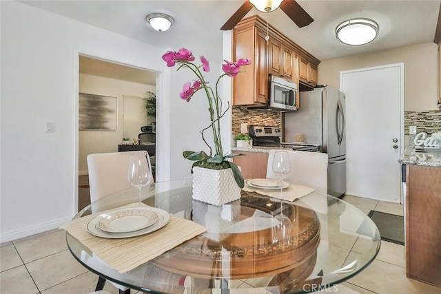 dining space with ceiling fan and light tile patterned floors