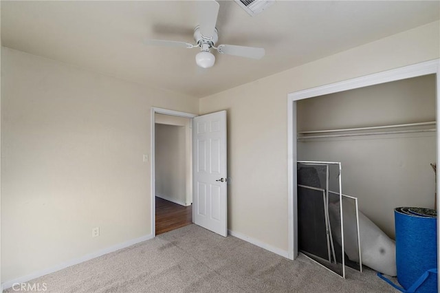 unfurnished bedroom featuring ceiling fan, a closet, and light colored carpet