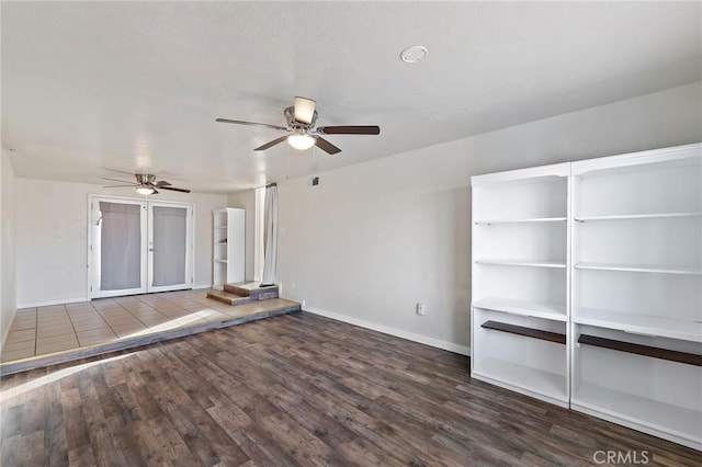 unfurnished living room with dark hardwood / wood-style flooring and ceiling fan