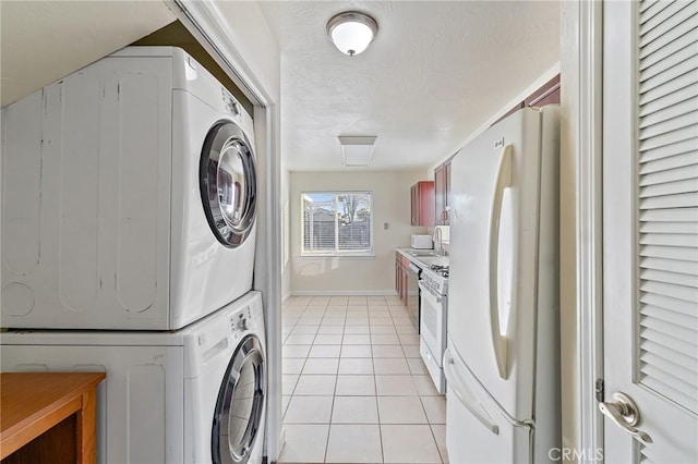 washroom featuring stacked washer / drying machine, light tile patterned floors, and sink