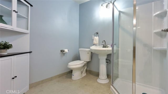 bathroom featuring toilet and a shower with shower door