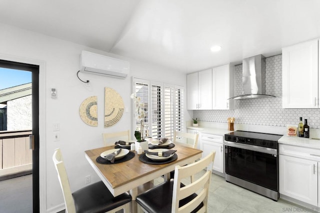 kitchen featuring white cabinetry, electric range, wall chimney exhaust hood, and an AC wall unit