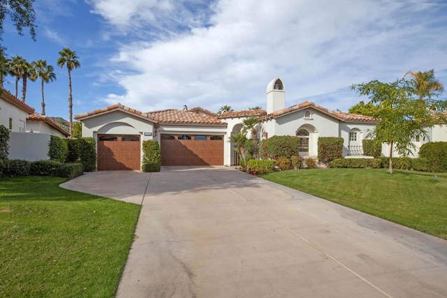 mediterranean / spanish-style home featuring a garage and a front lawn