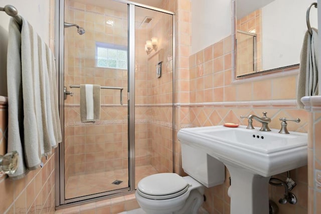 bathroom featuring toilet, tile walls, backsplash, and walk in shower