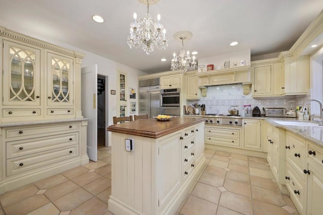 kitchen featuring appliances with stainless steel finishes, pendant lighting, and cream cabinets