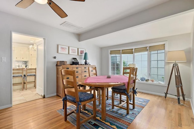 dining area featuring ceiling fan with notable chandelier and light wood-type flooring