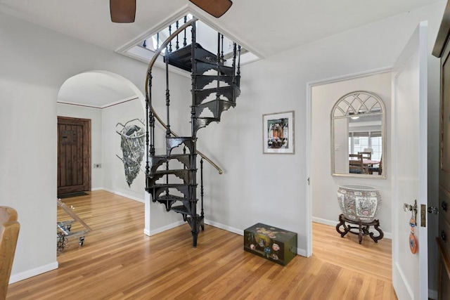 stairs with hardwood / wood-style flooring and ceiling fan