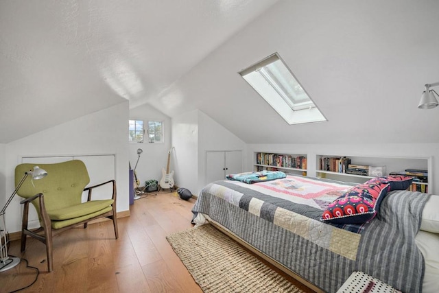 bedroom featuring hardwood / wood-style flooring and vaulted ceiling with skylight