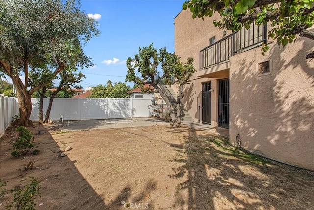 view of yard featuring a balcony and a patio