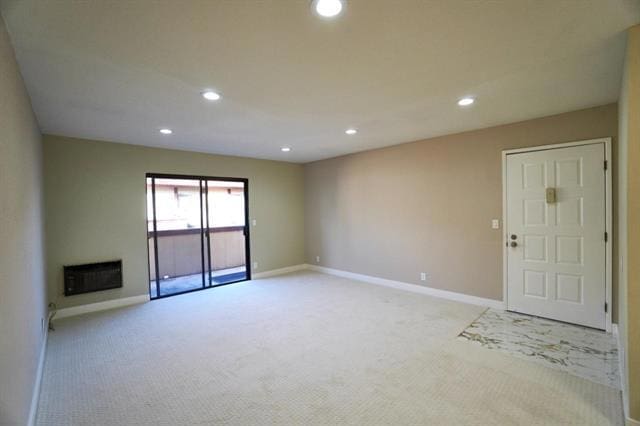 unfurnished living room with light carpet and heating unit