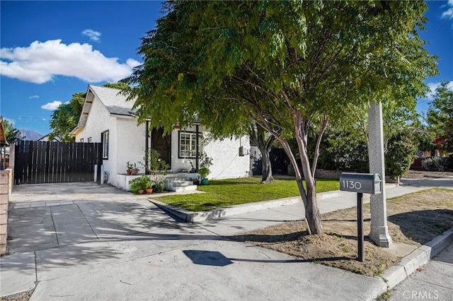 view of front facade featuring a front yard, fence, and stucco siding