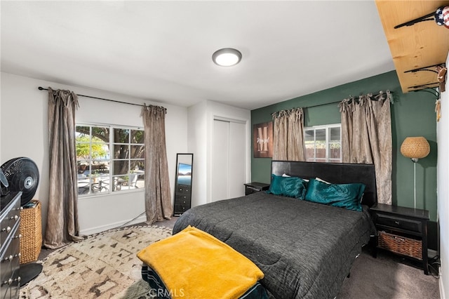 carpeted bedroom with a closet and multiple windows