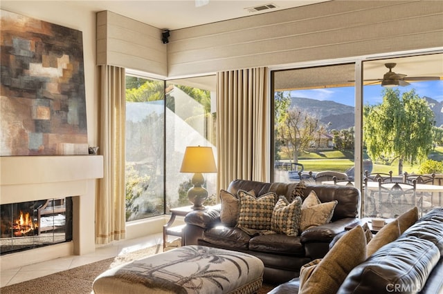 interior space featuring ceiling fan, a mountain view, and light tile patterned floors