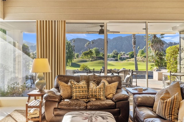 sunroom / solarium featuring ceiling fan and a mountain view