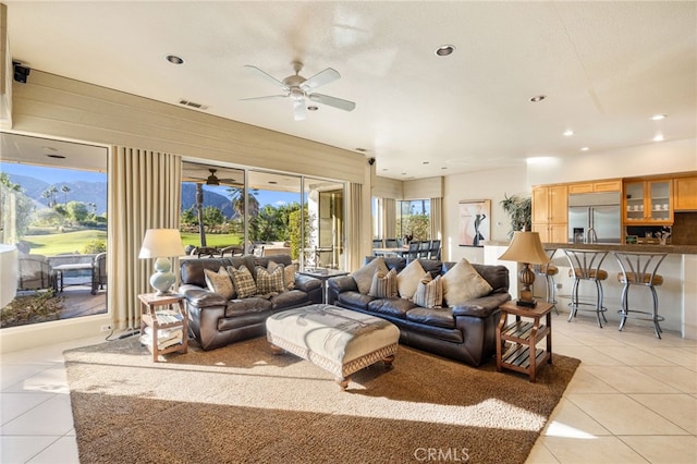 tiled living room with a mountain view, a textured ceiling, and ceiling fan