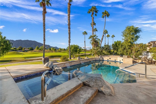 view of pool featuring a hot tub, a mountain view, and a patio