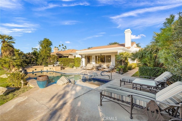 view of swimming pool with a hot tub and a patio