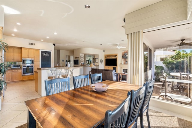 dining area with light tile patterned floors, sink, and ceiling fan