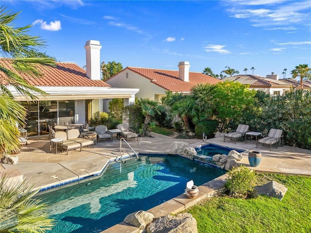 view of pool featuring an in ground hot tub and a patio