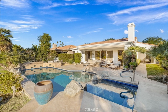 view of pool with a patio area, ceiling fan, and an in ground hot tub