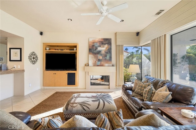 living room with light tile patterned floors, built in features, and ceiling fan